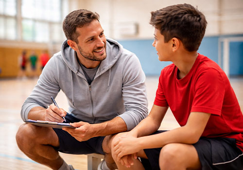 Trainer redet mit Kind